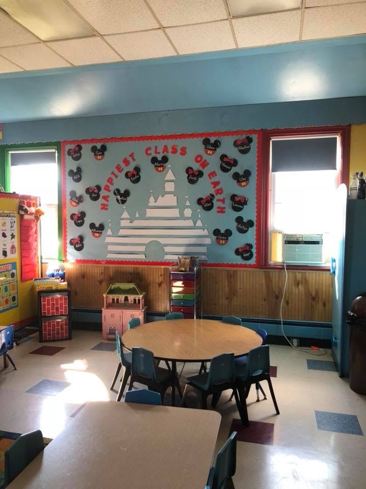 Classroom with tables and chairs, a bulletin board with a castle and text
