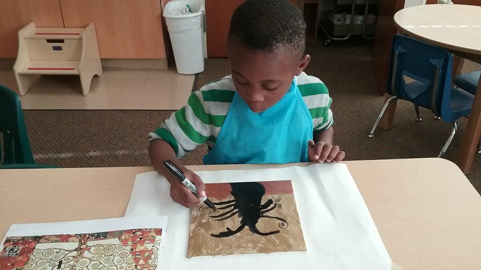 Child drawing on paper with a marker
