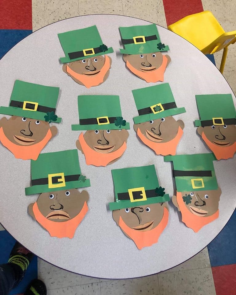 Leprechaun craft faces with green hats and orange beards on a table