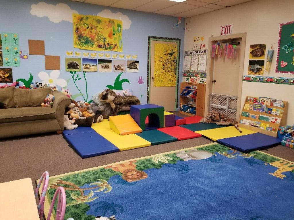 Playroom with colorful mats, a sofa, and decorated walls