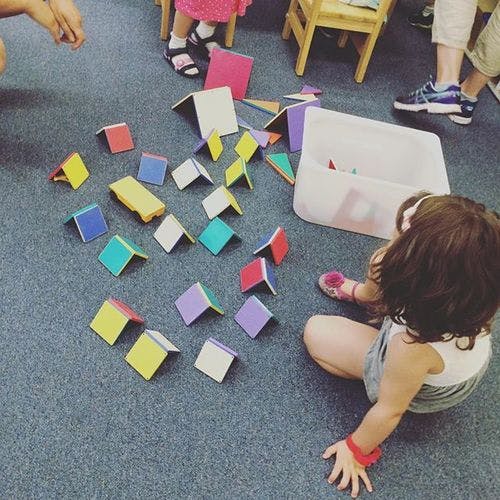 Child playing with colorful magnetic tiles on a carpeted floor
