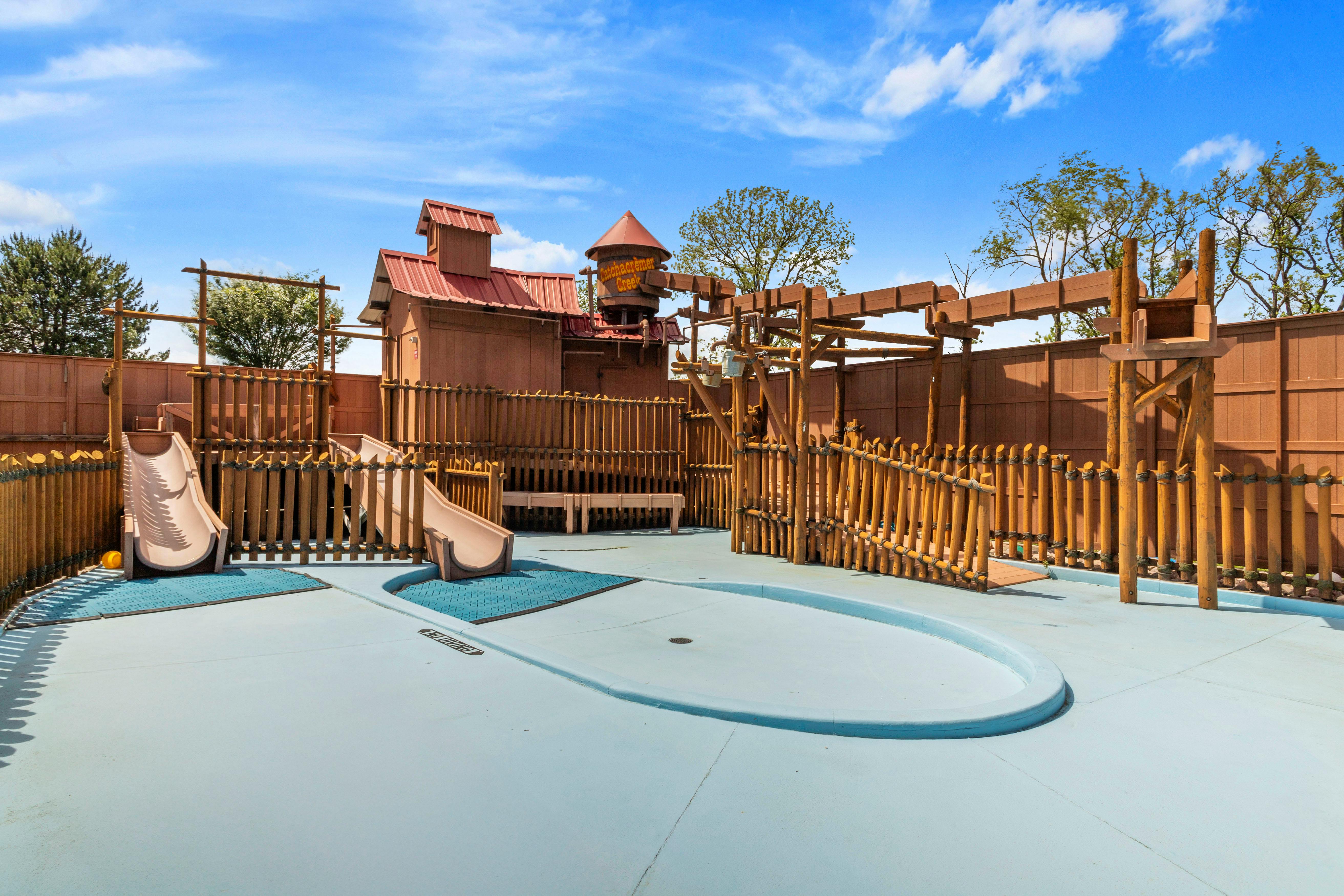 Water park play area with slides, a water tower labeled "Watchacremek Creek," and wooden fences
