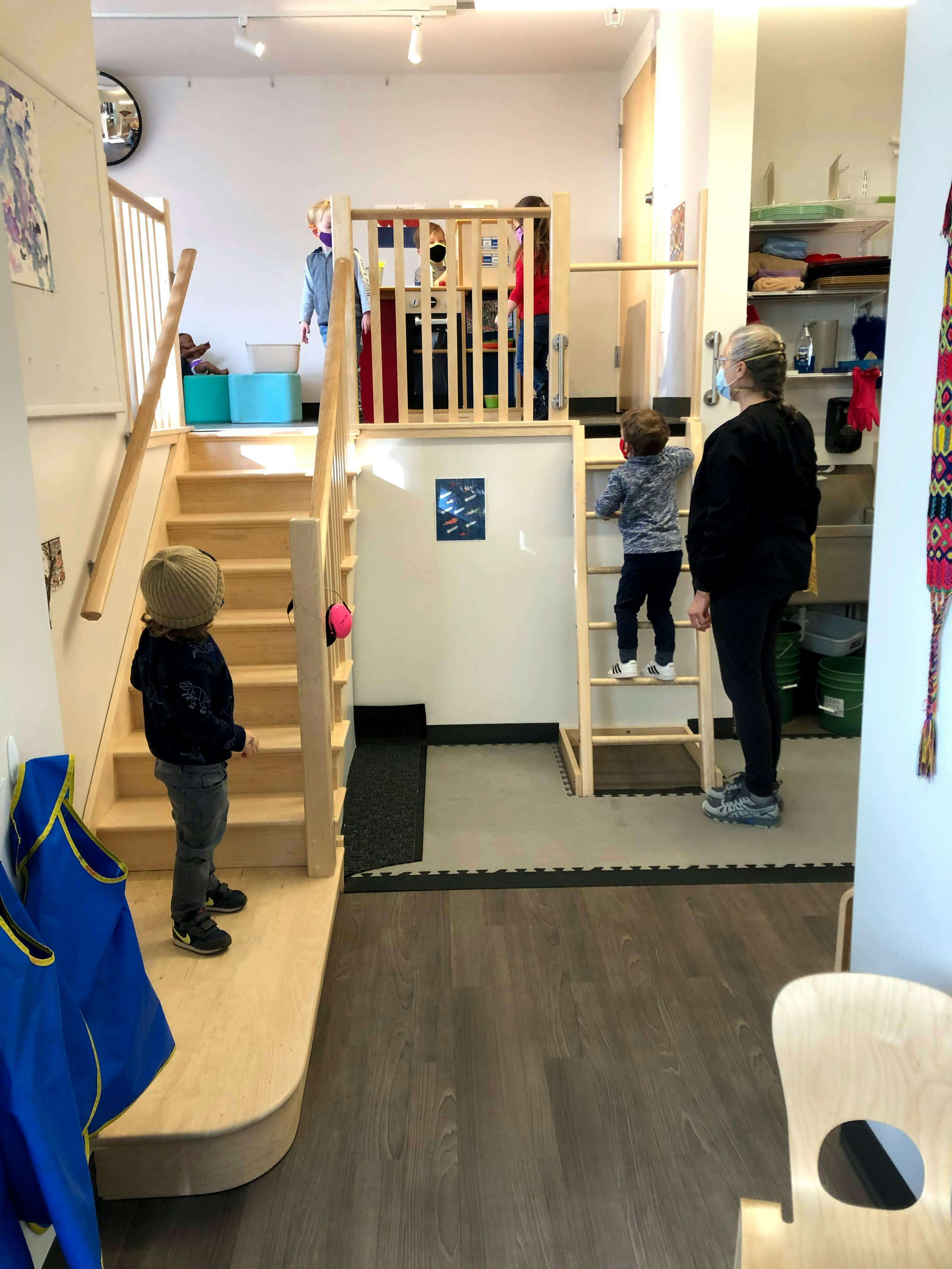 Person and child on a ladder, another child on stairs