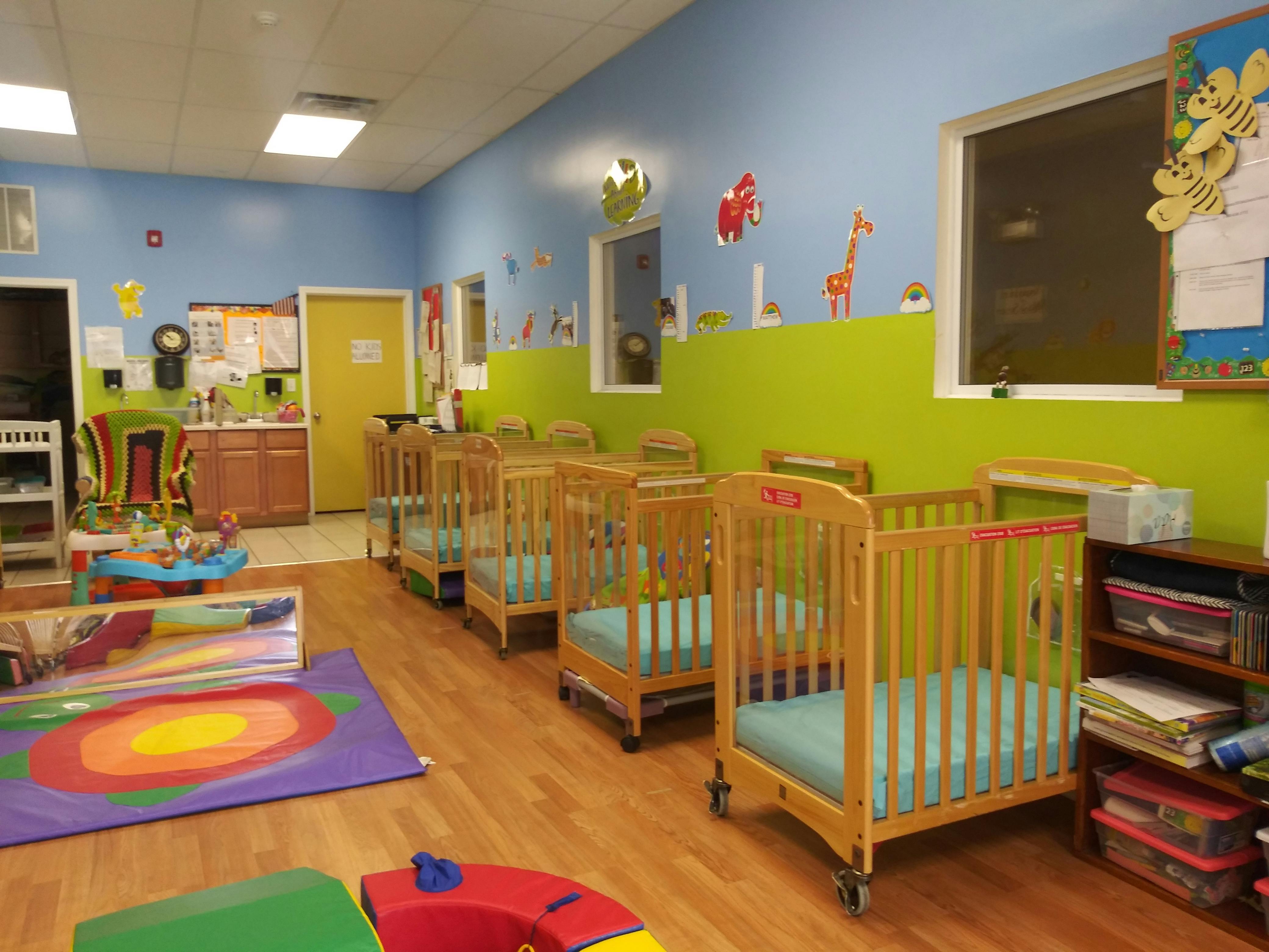 Row of cribs in a brightly colored room