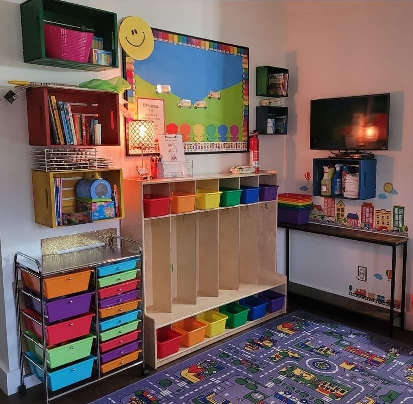 Classroom with colorful storage bins, shelves, and a TV