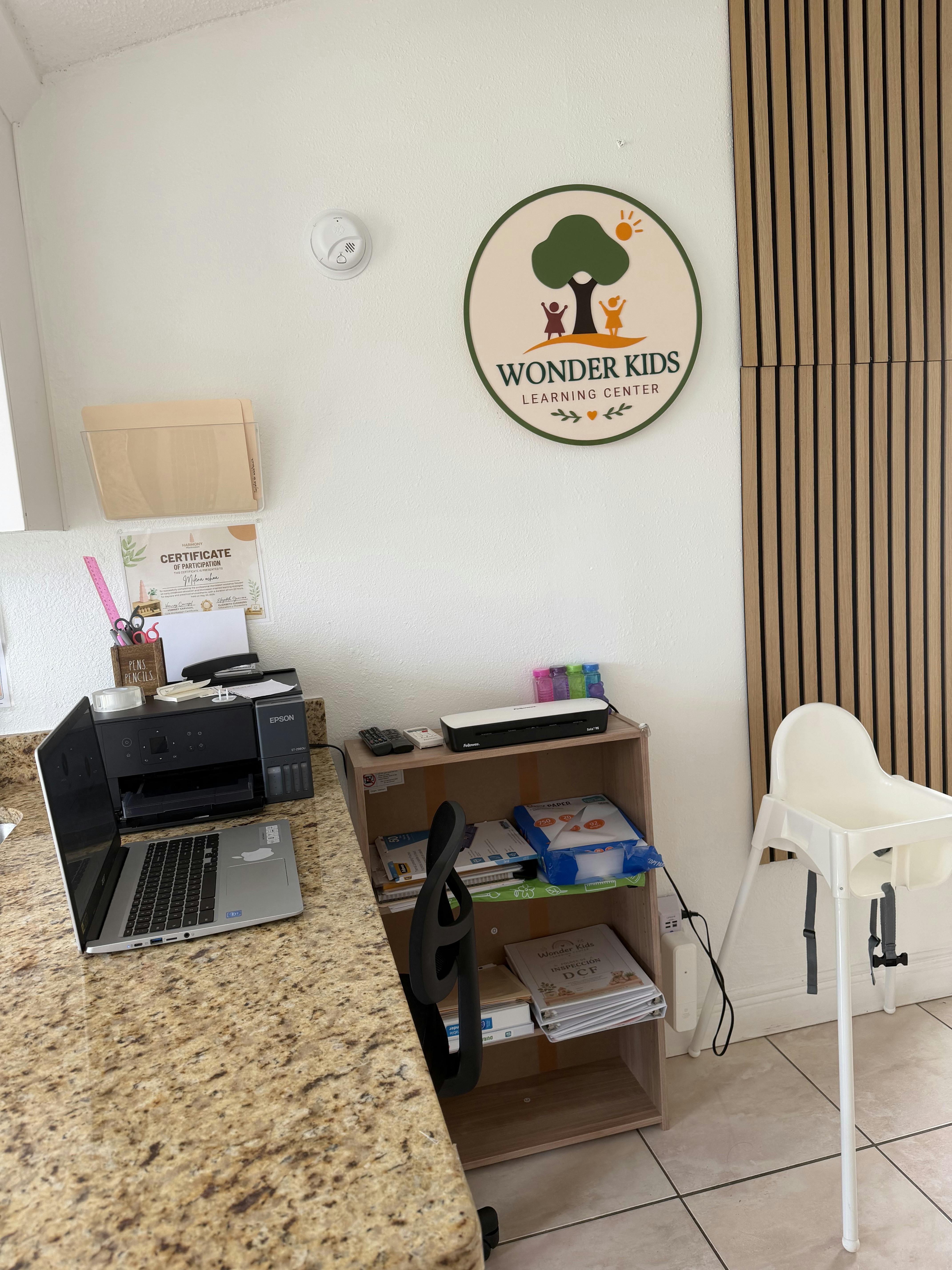 Sign for Wonder Kids Learning Center with office desk and high chair