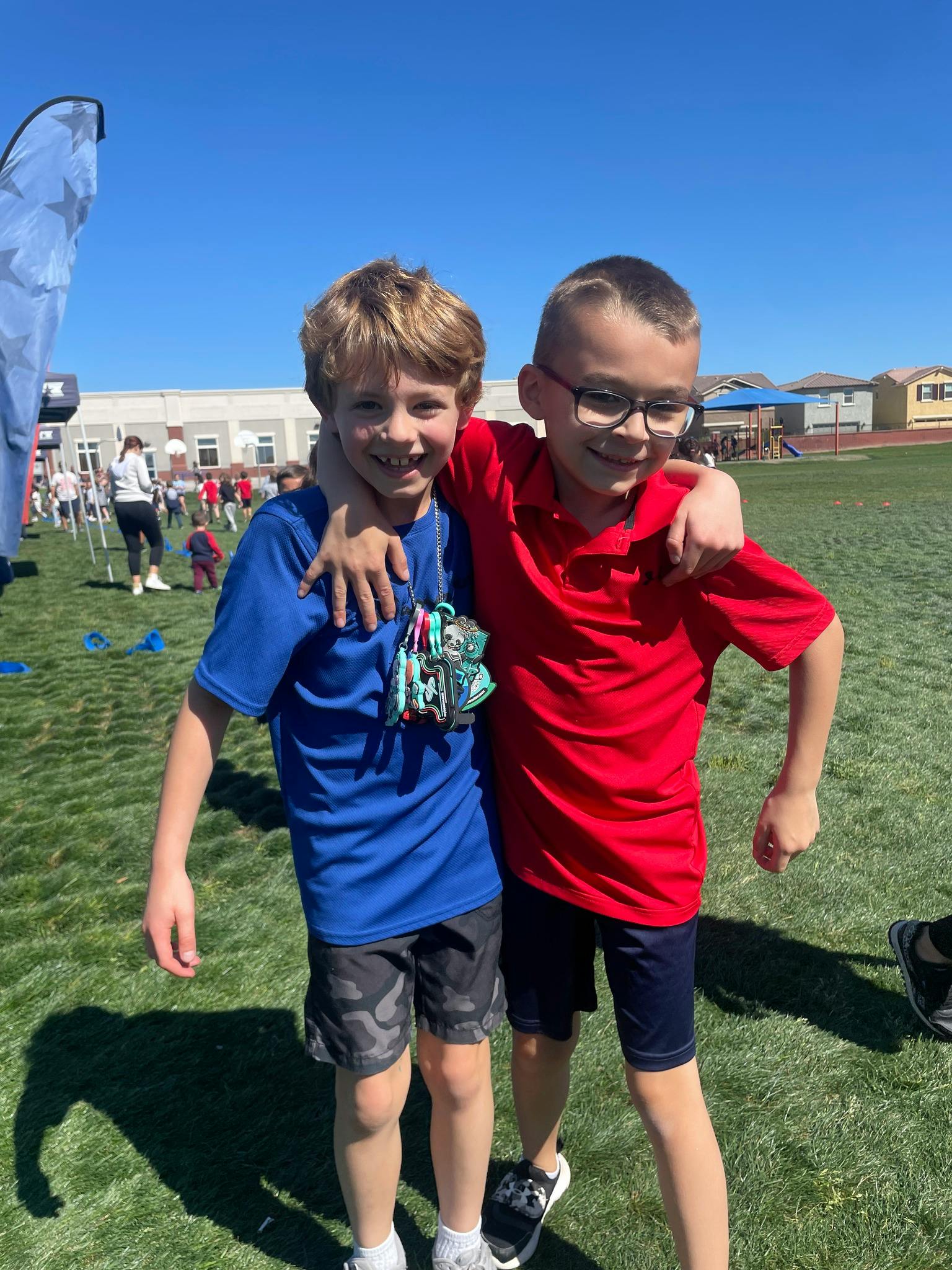 Two children standing on grass with arms around each other