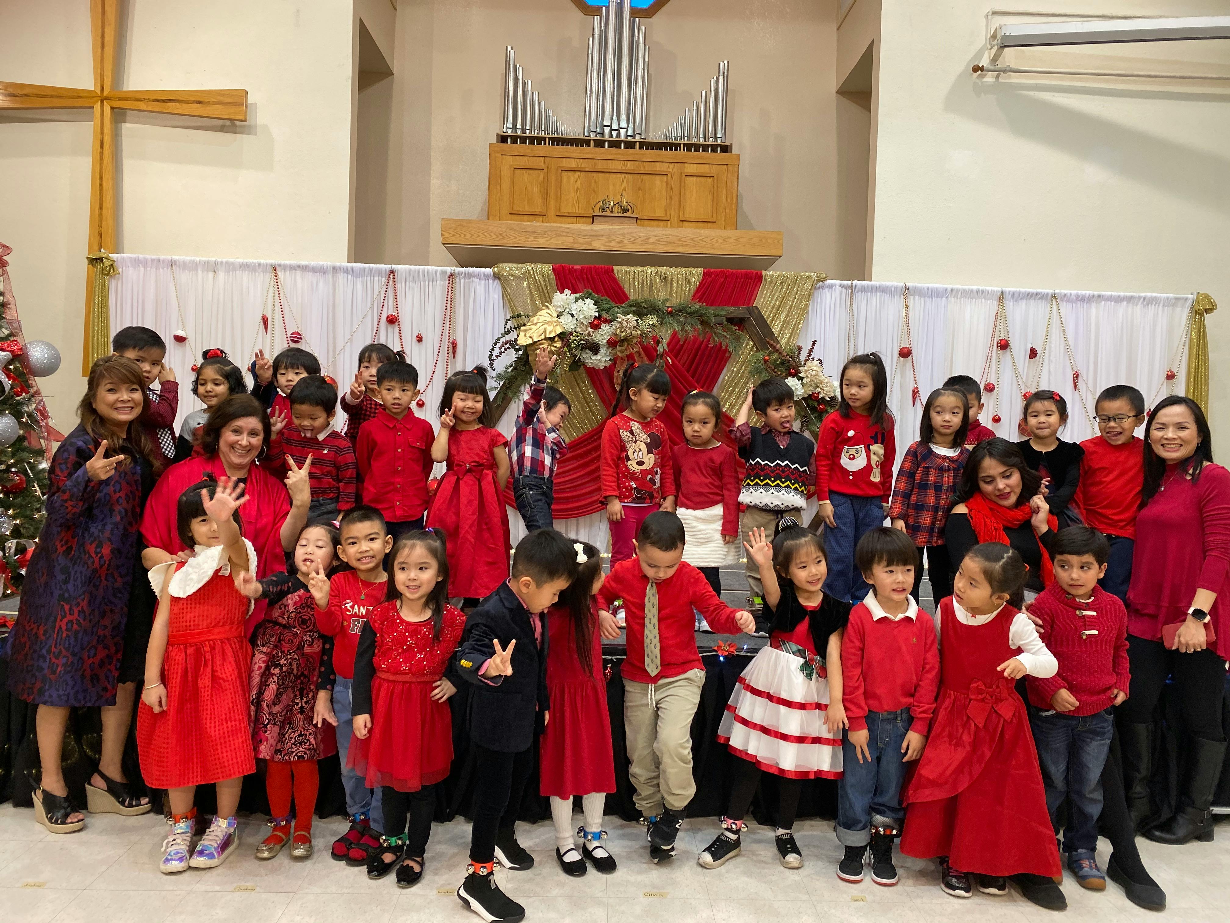 Group of adults and children in red clothing posing indoors