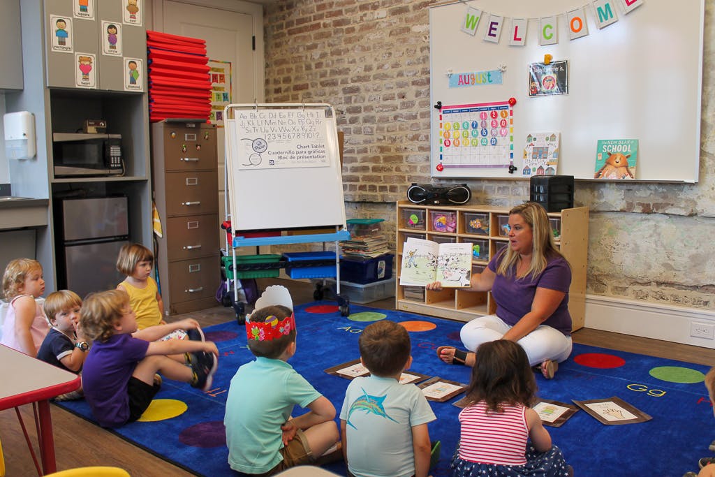 Adult person reading to children in a classroom