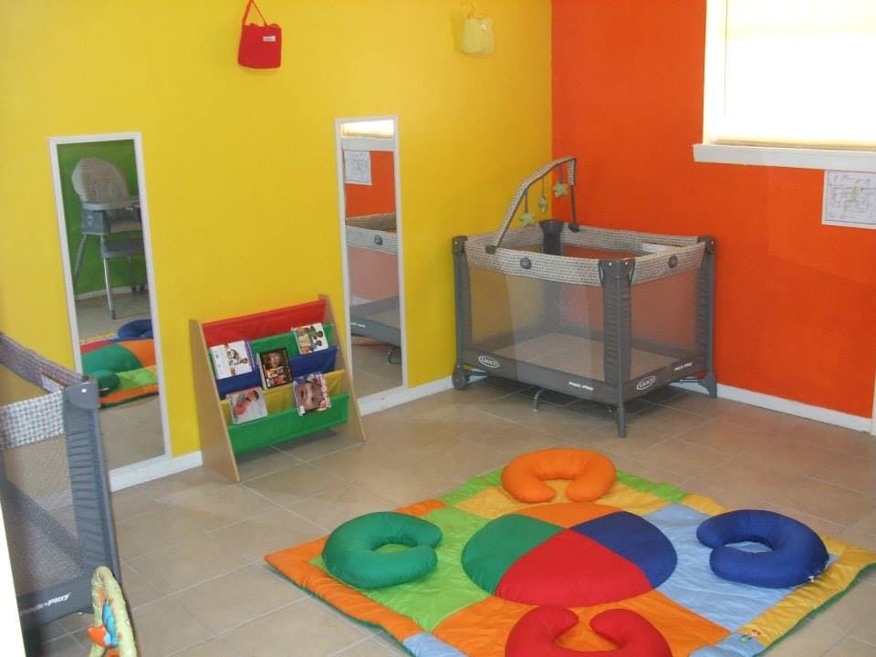 Playroom with colorful walls, playpen, and activity mat