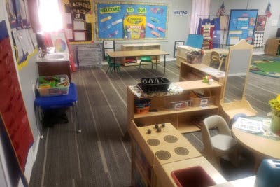 Playroom with small tables, chairs, and play kitchen