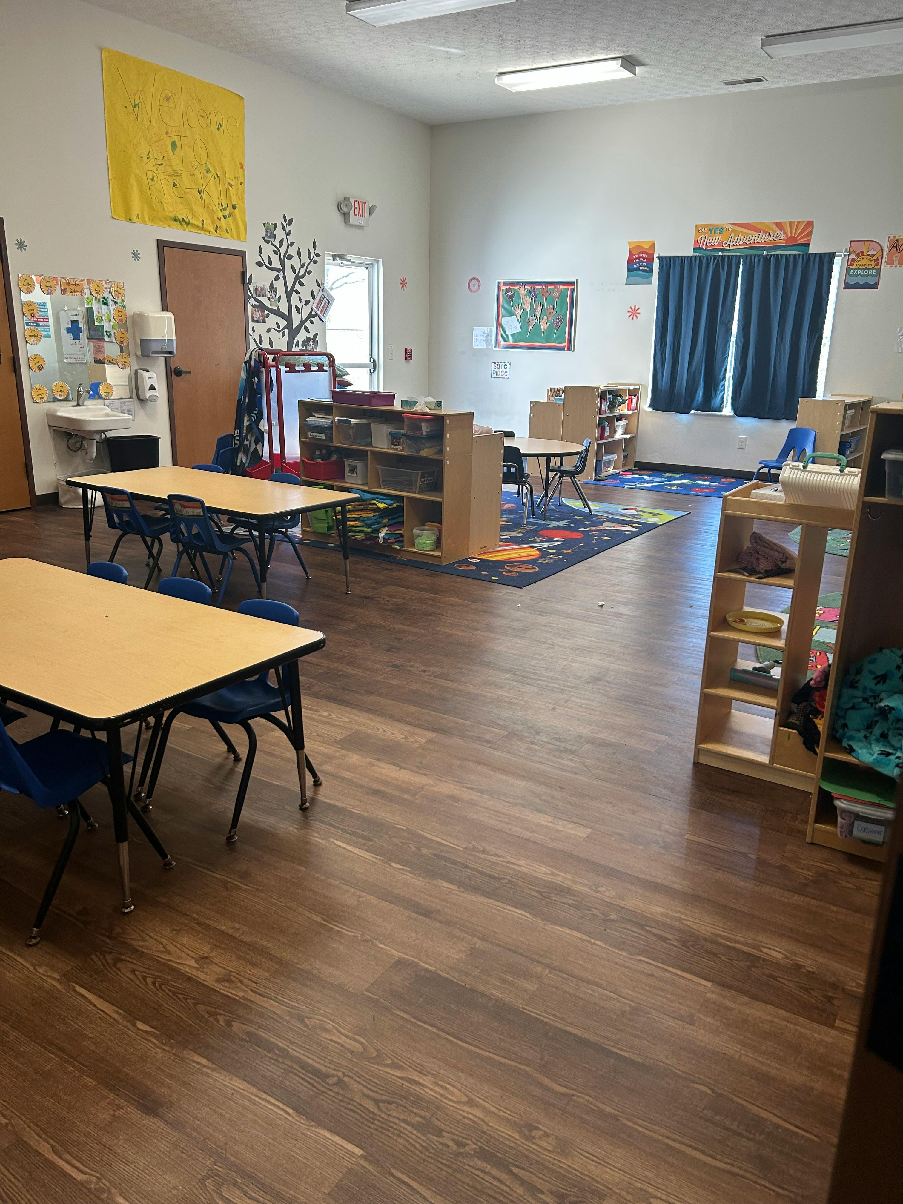 Classroom with tables, chairs, and shelves