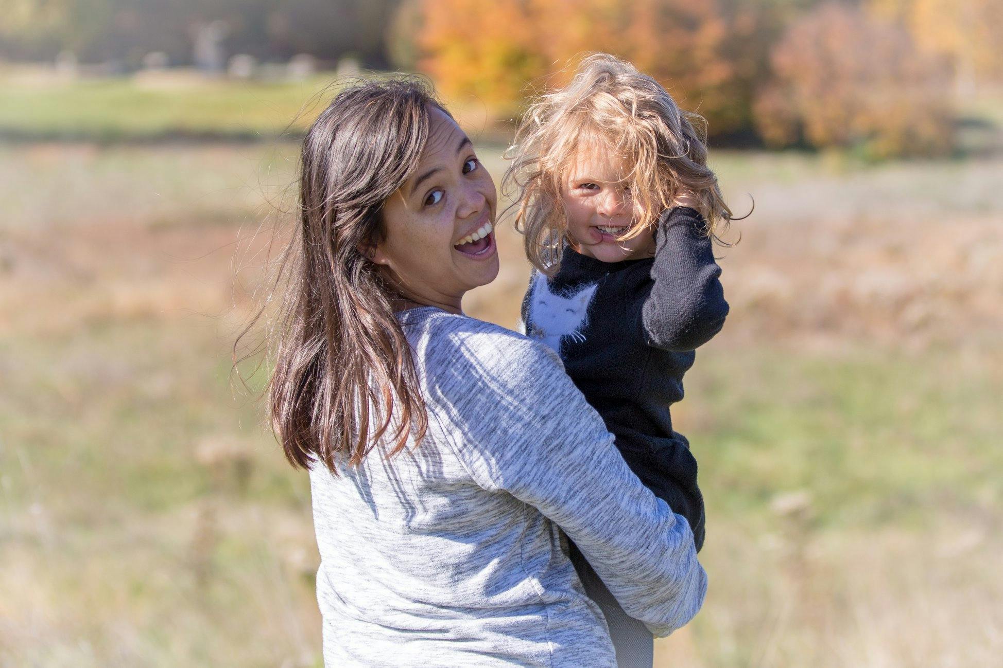 Person holding a child outdoors