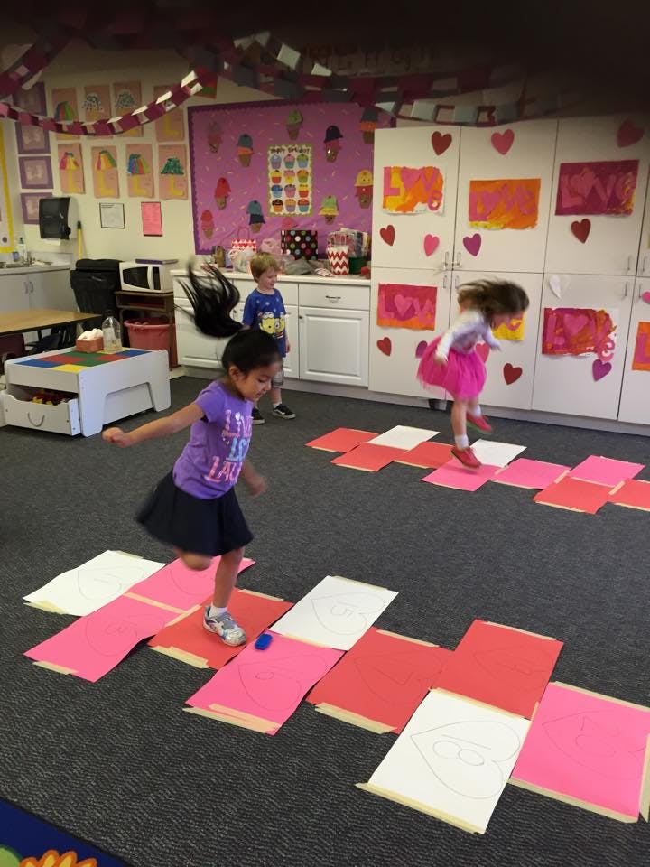 Children playing on paper squares on the floor