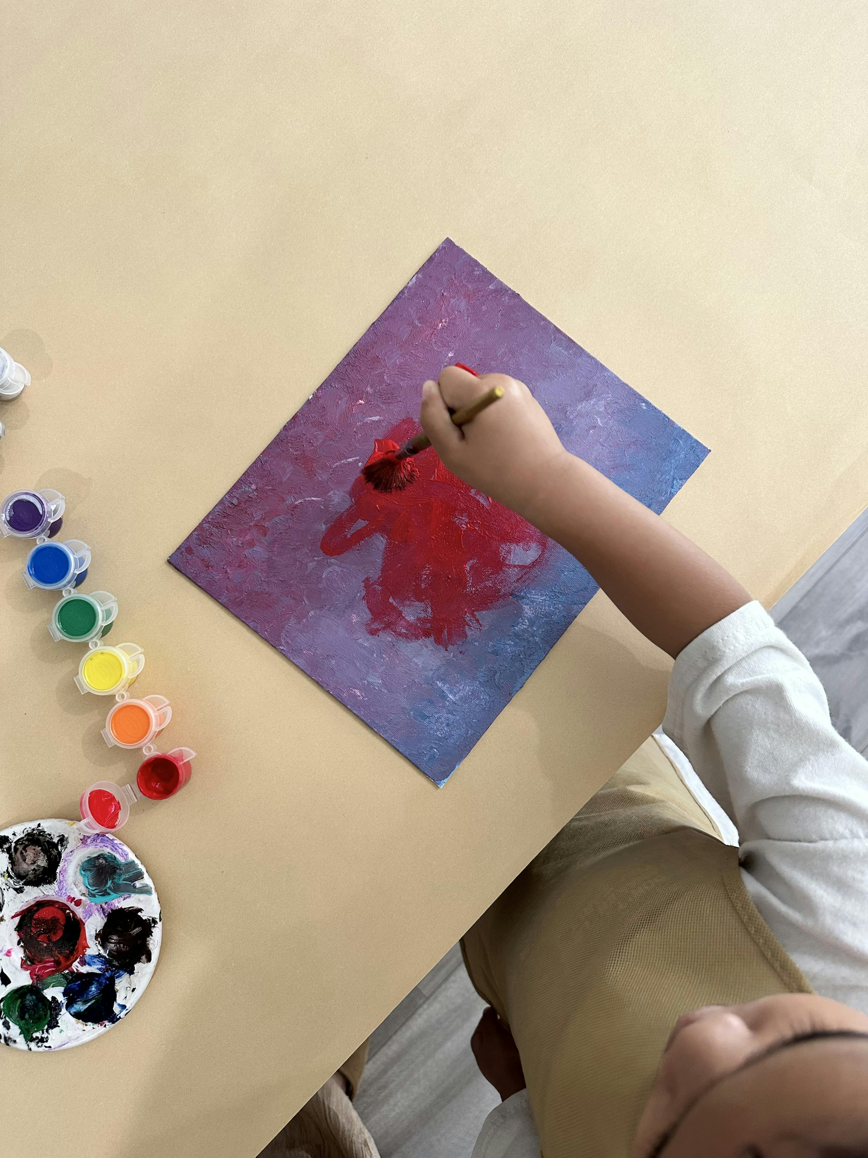 Child painting on canvas with a brush