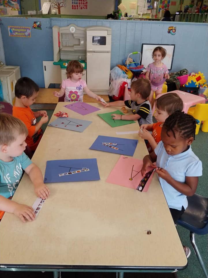 Children sitting at a table doing crafts in-class activities