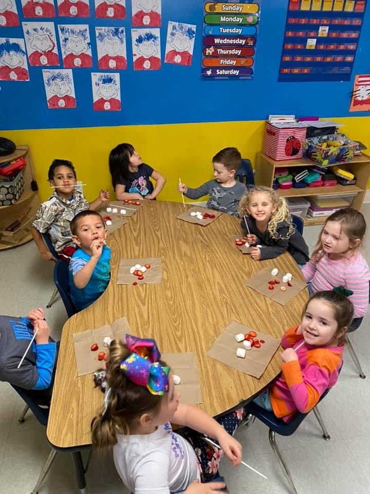 Children sitting around a table with craft supplies
