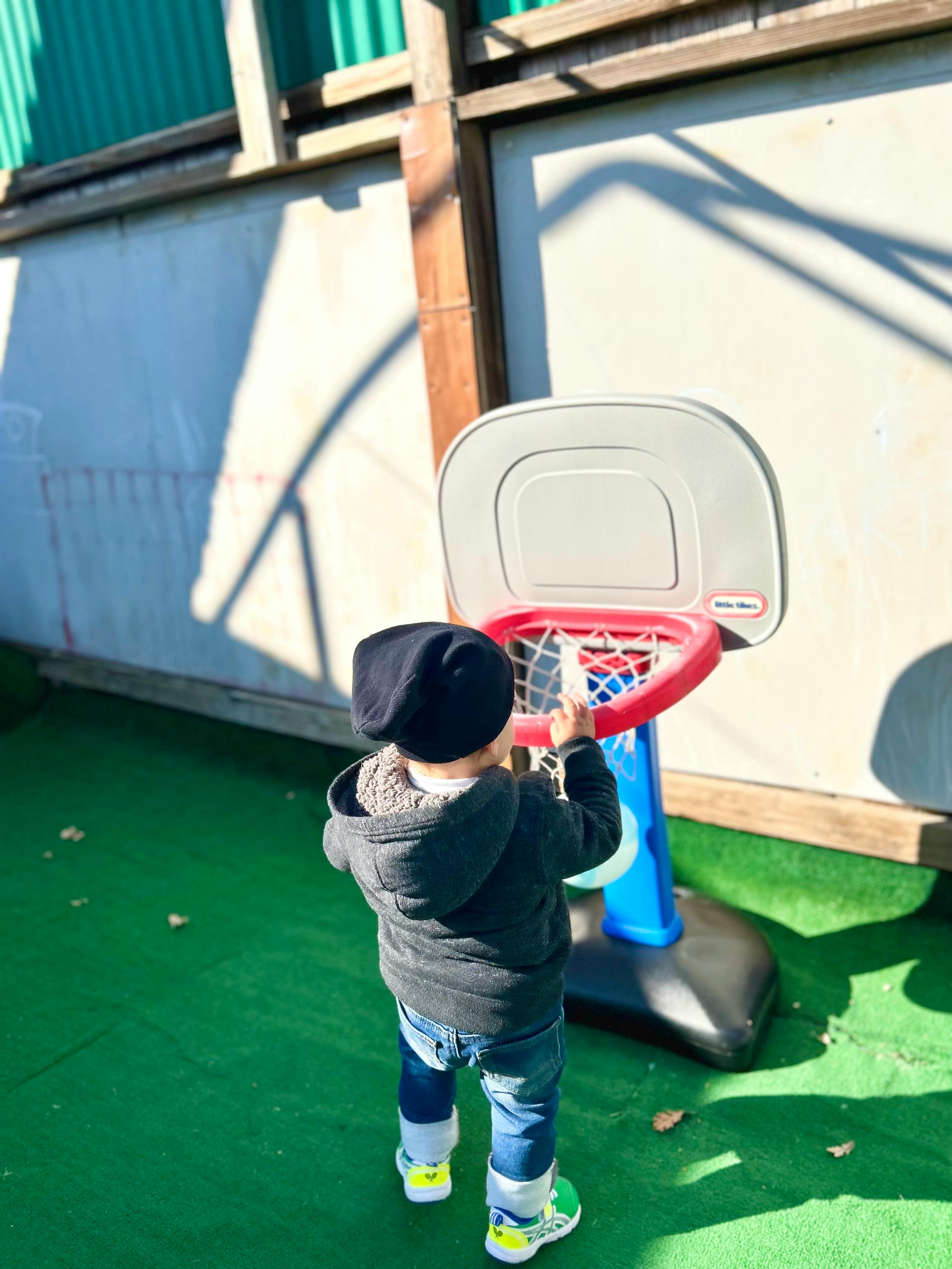Child playing with a toy basketball hoop