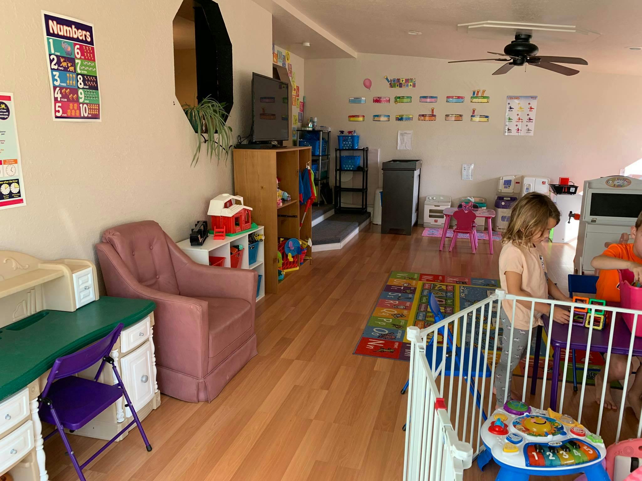Two children playing in a room with toys and furniture