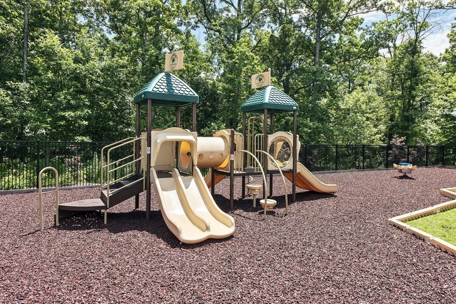 Playground with slides, tunnels, and climbing structures on wood chip ground
