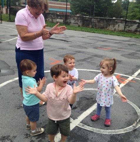Adult and three children playing outdoors