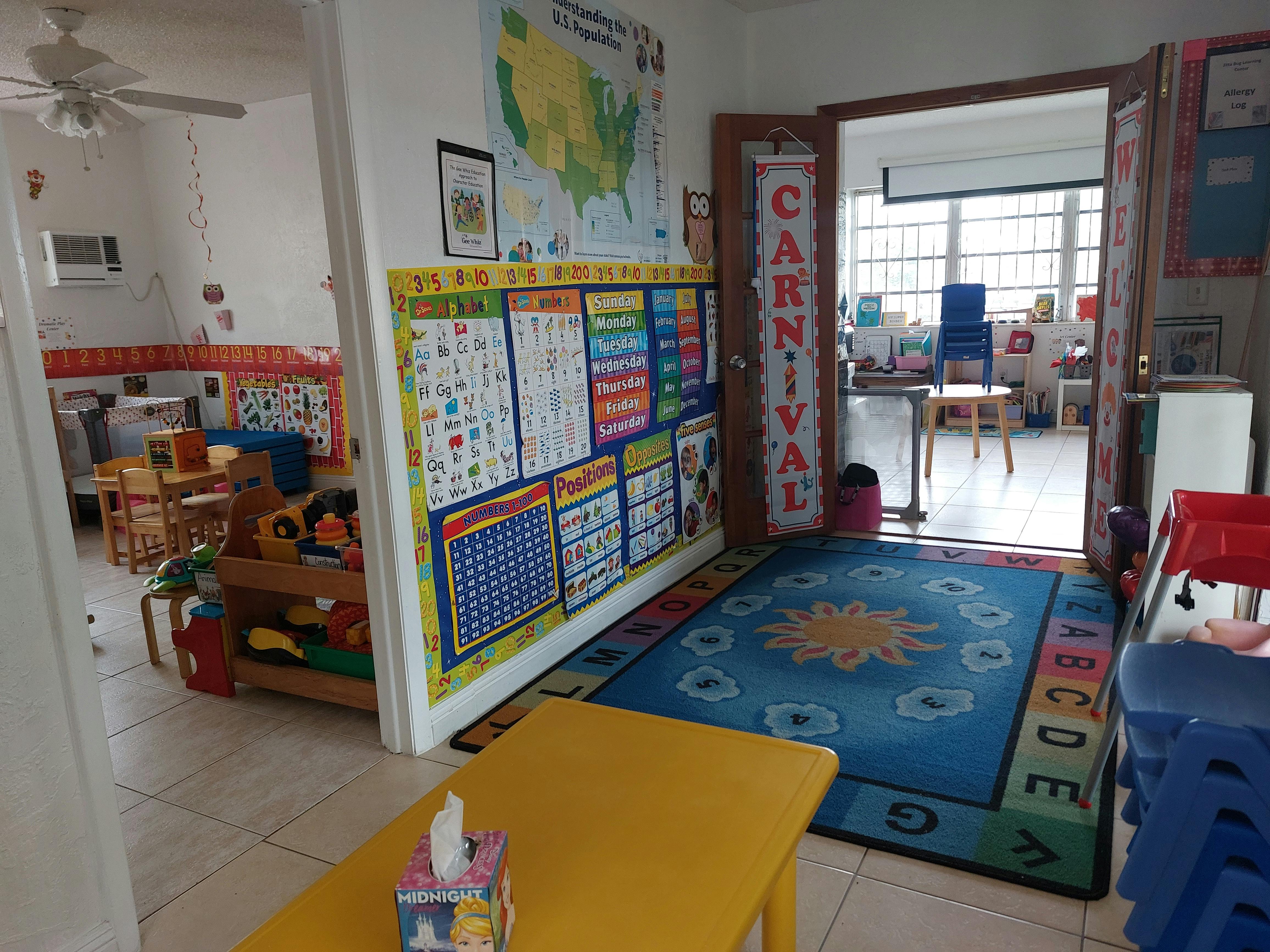 Classroom with a colorful rug, bulletin board, and open doorway