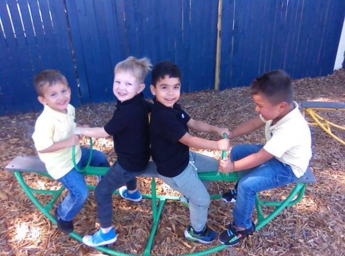 Four children playing on a seesaw