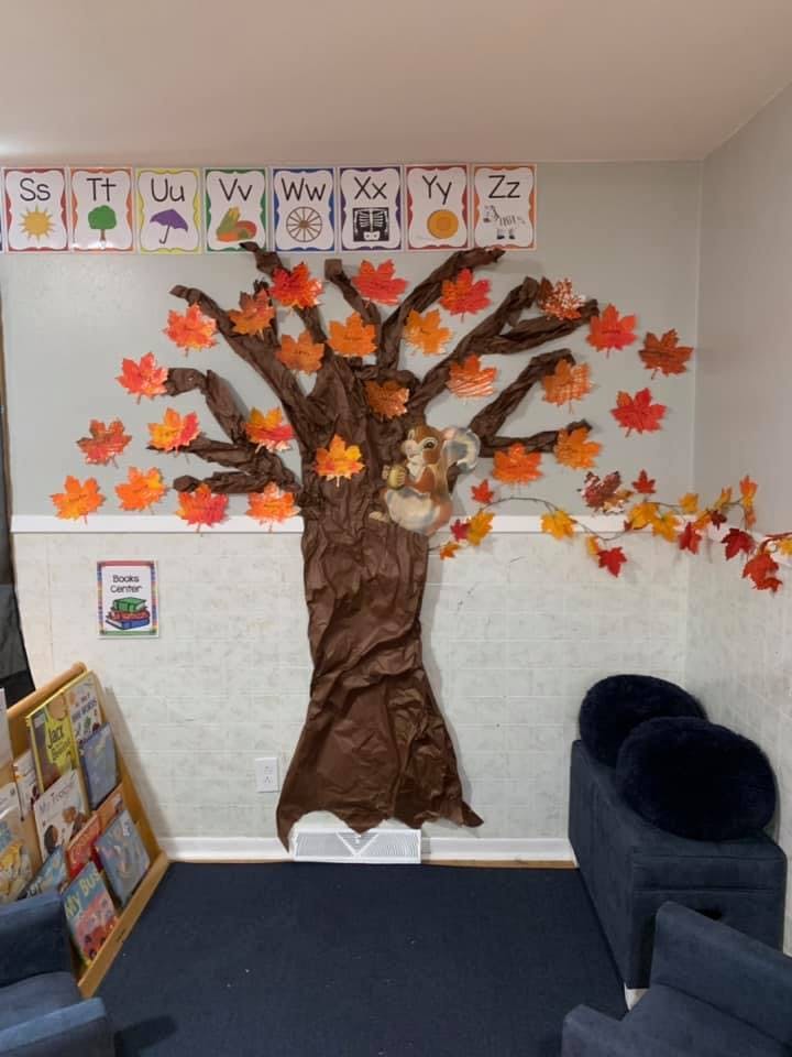 Fall-themed classroom decoration with a tree, leaves, and alphabet cards