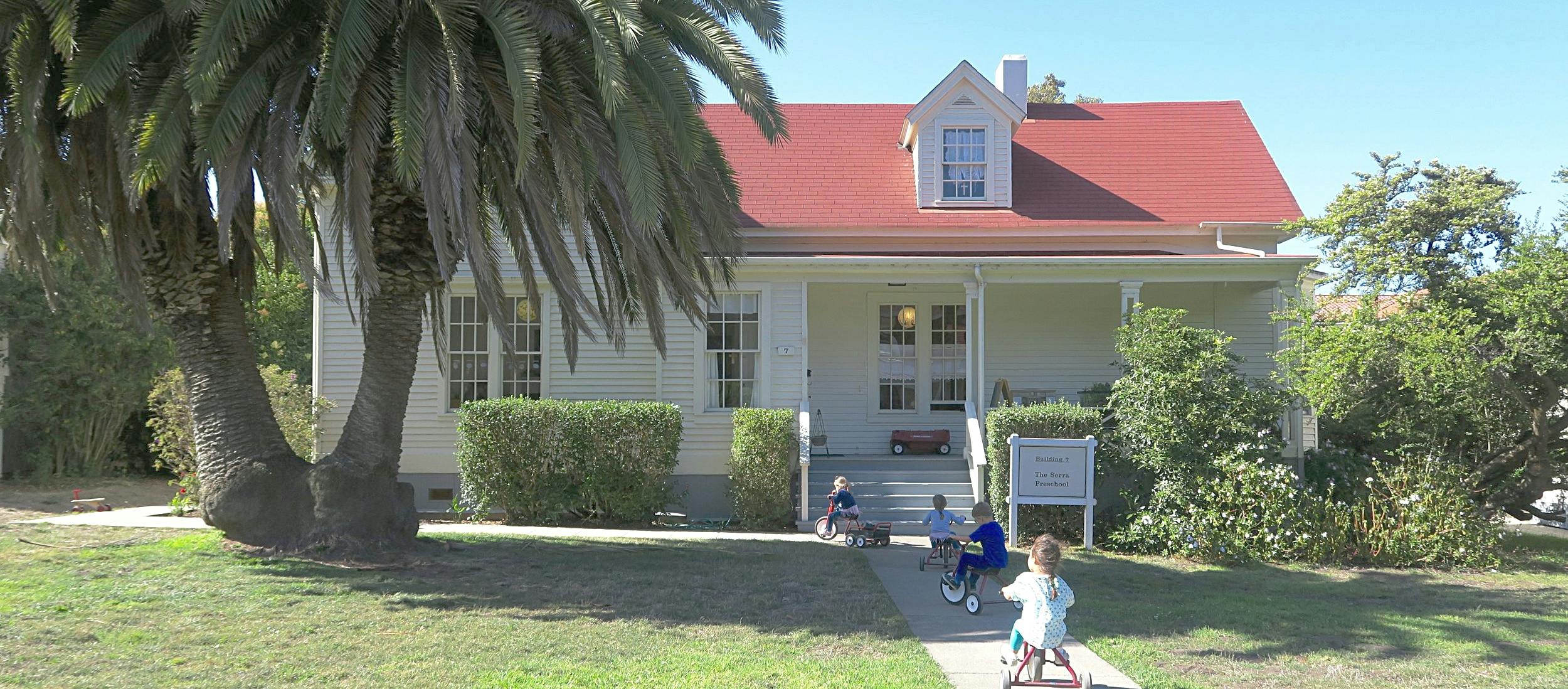 House with red roof and children on the walkway