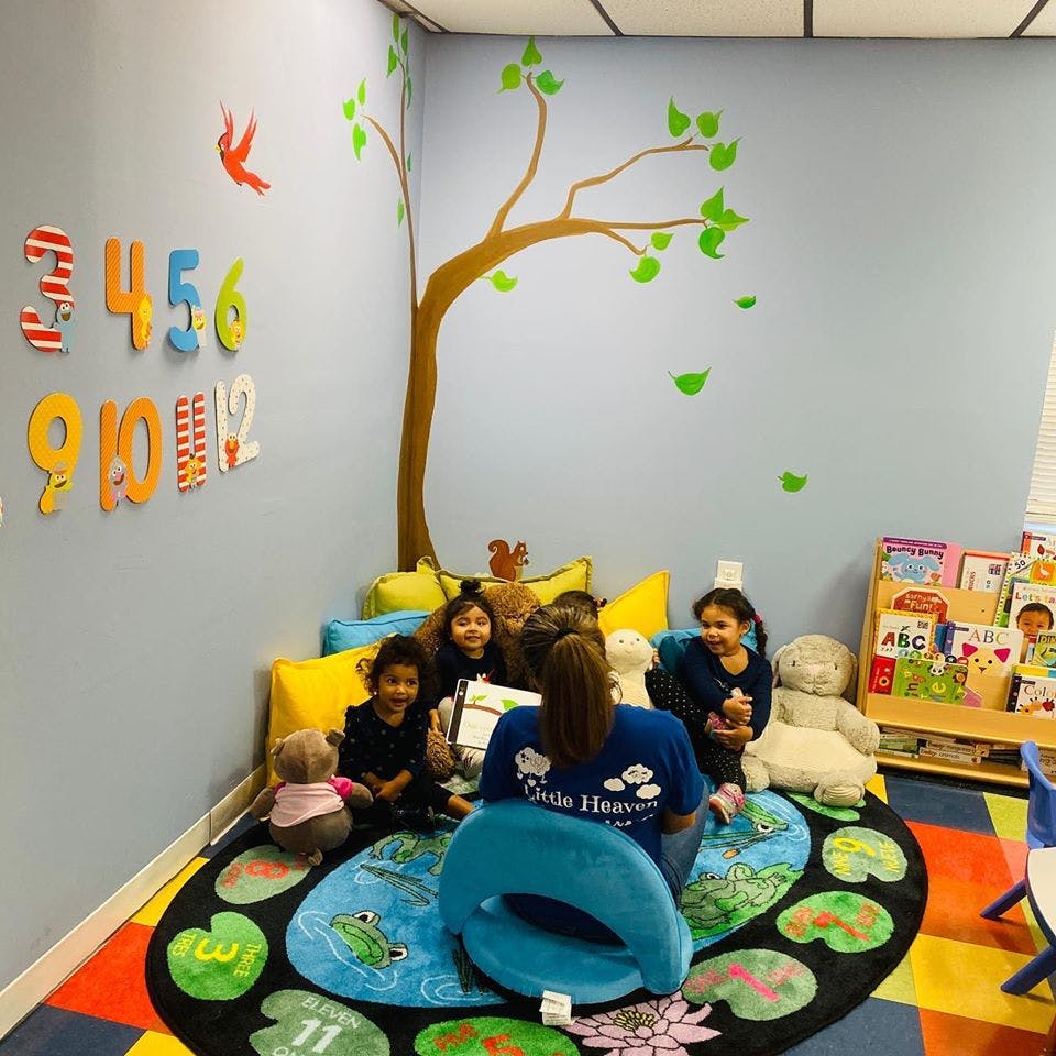 Adult and children sitting on a rug in a classroom