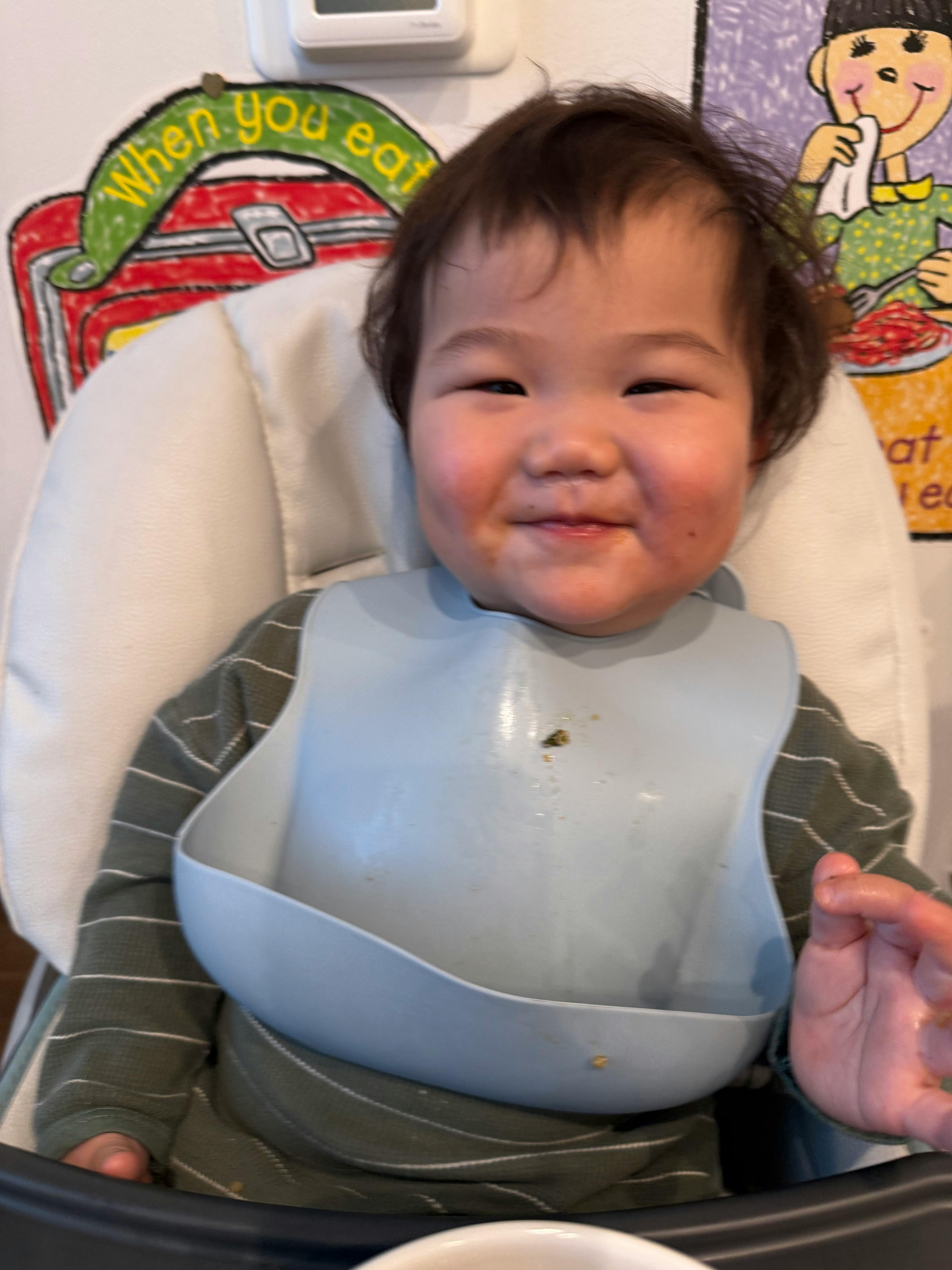Child in a high chair wearing a bib