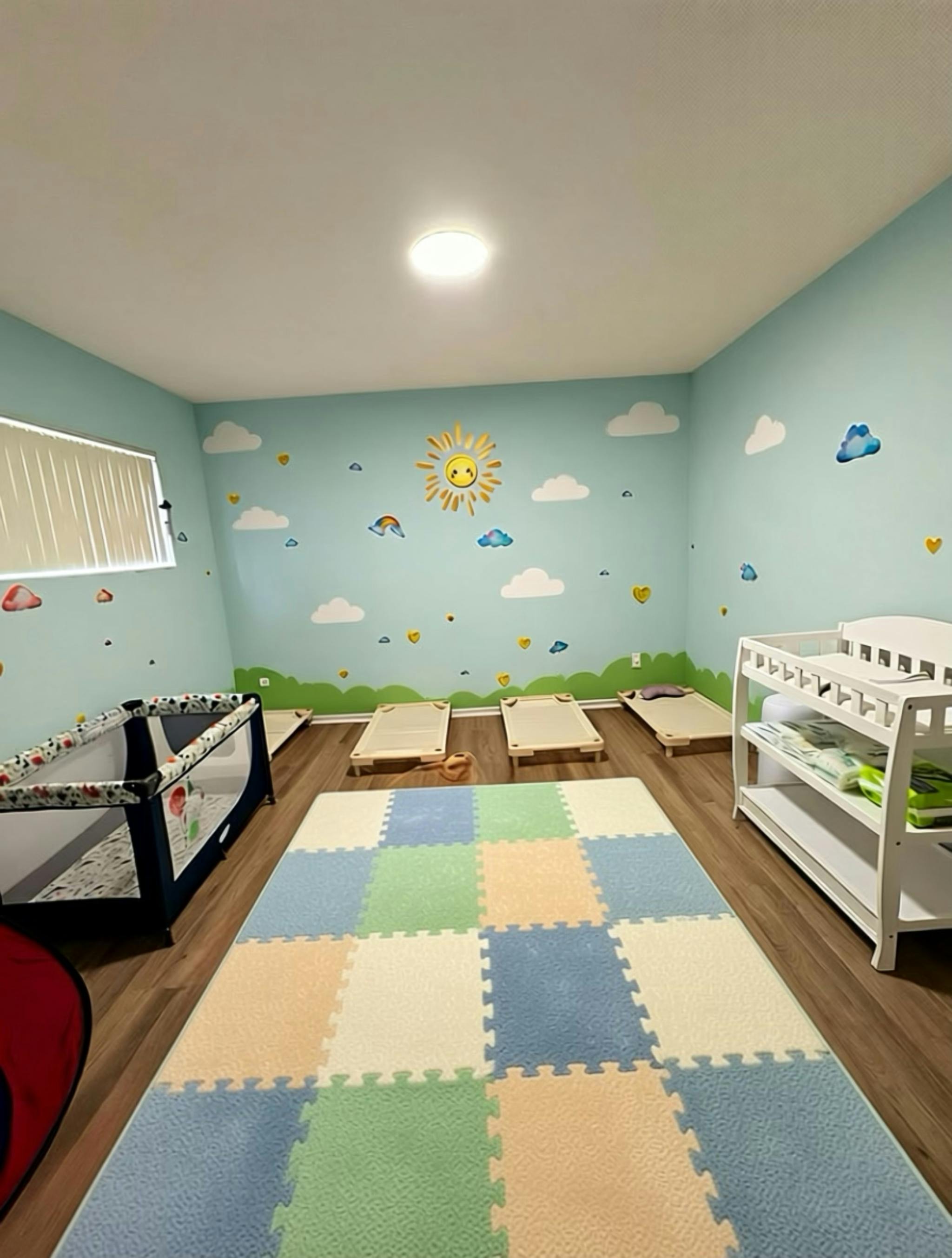 nursery room with cots, changing table, playpen, and colorful wall decorations