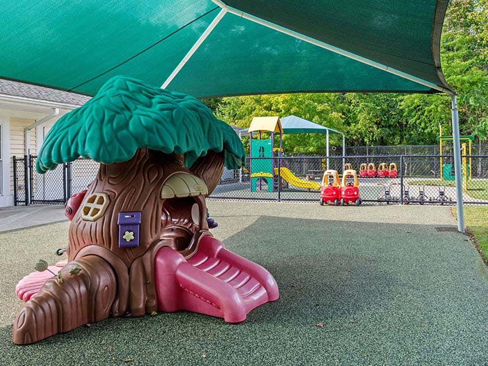 A tree-shaped playhouse with a slide on a playground