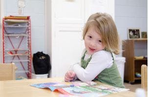 Child sitting at a table with an open book
