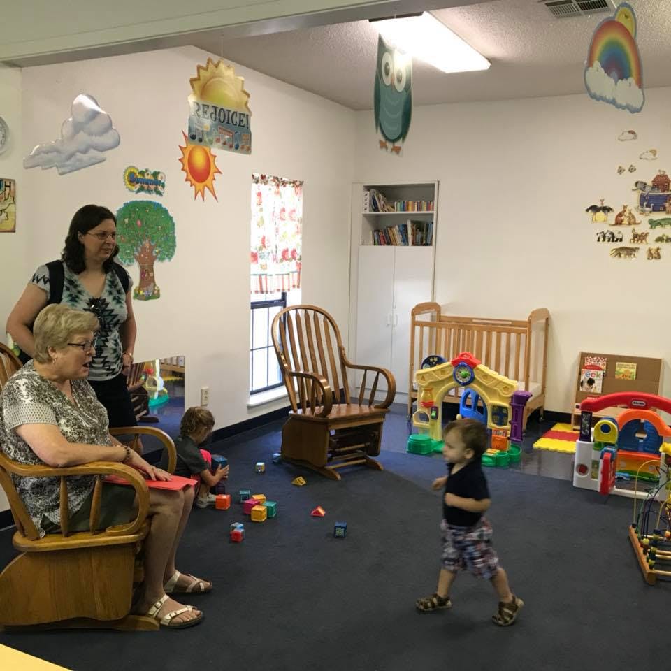 Two adults and two children in a room with toys