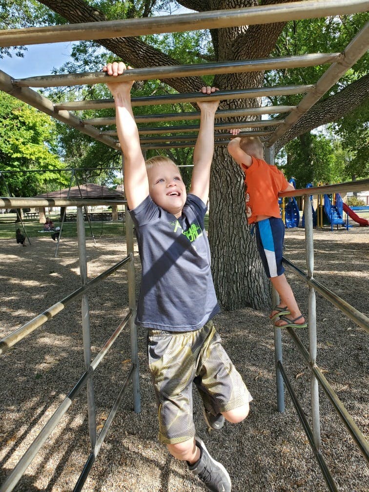 Child hanging from monkey bars on a playground