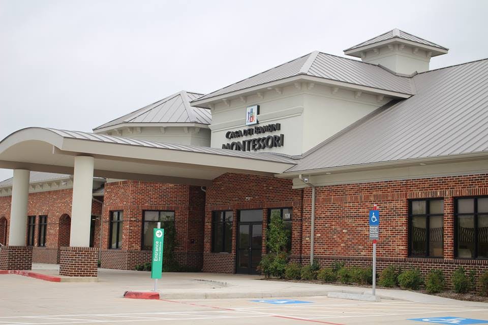 Building with brick facade and covered entrance, columned entrance