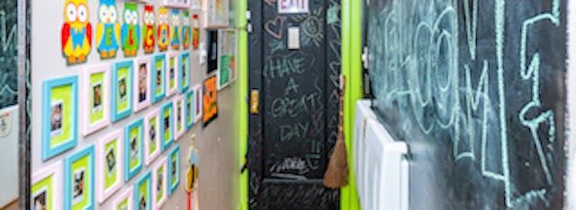 Hallway with framed pictures, a chalkboard door, and a chalkboard wall