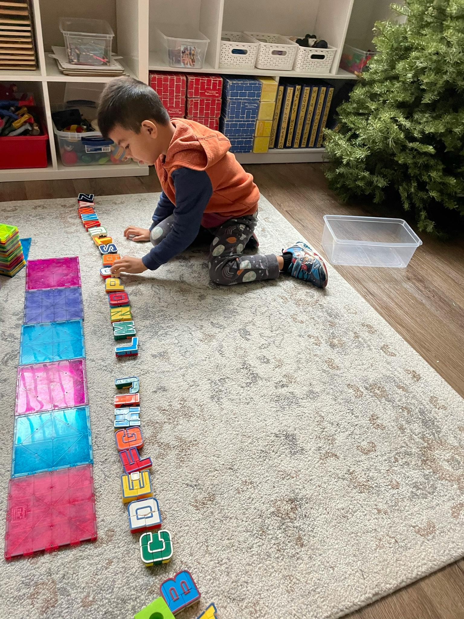 Child playing with alphabet blocks on a rug
