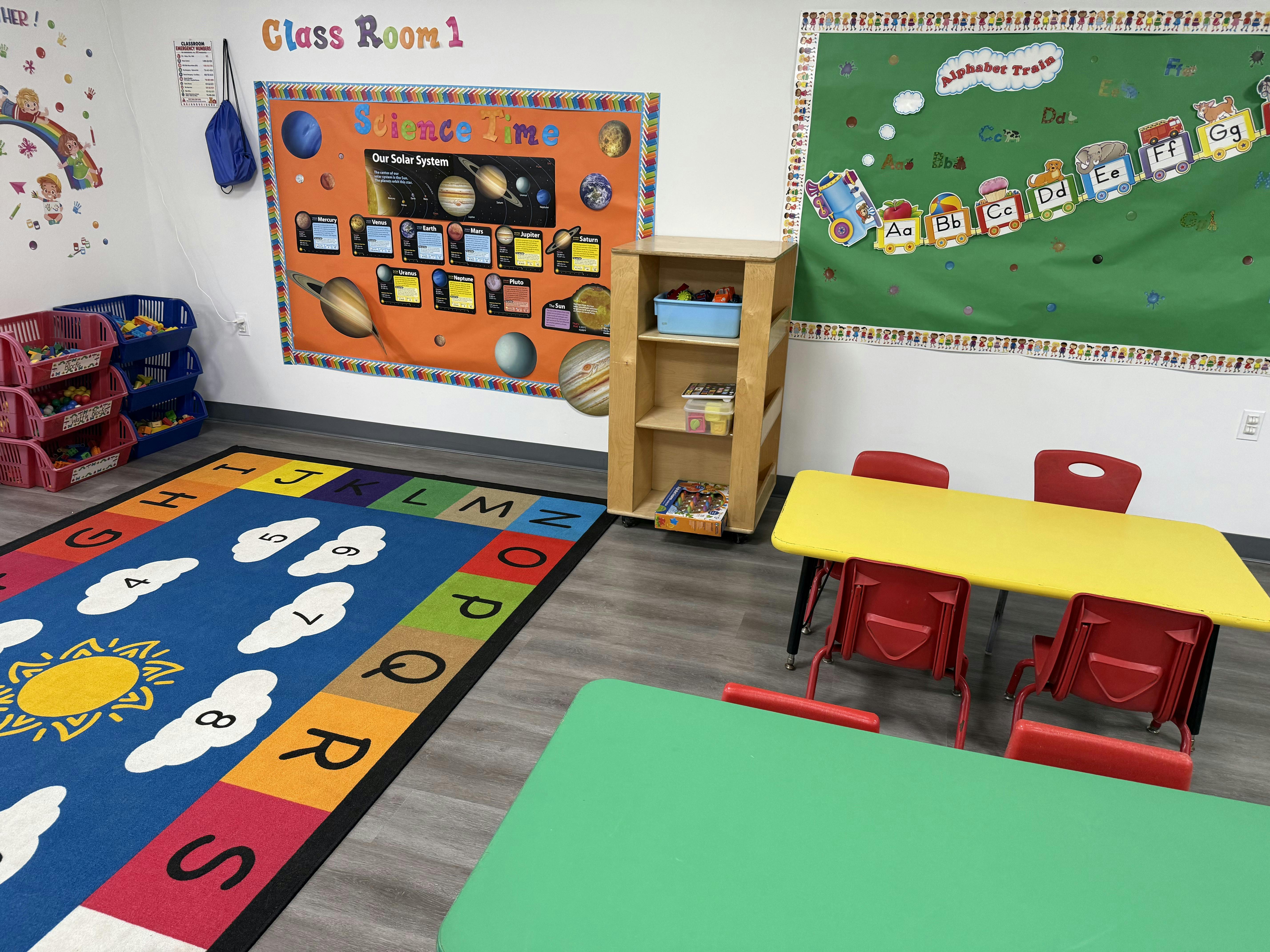 Colorful preschool classroom interior with educational wall posters and rugs