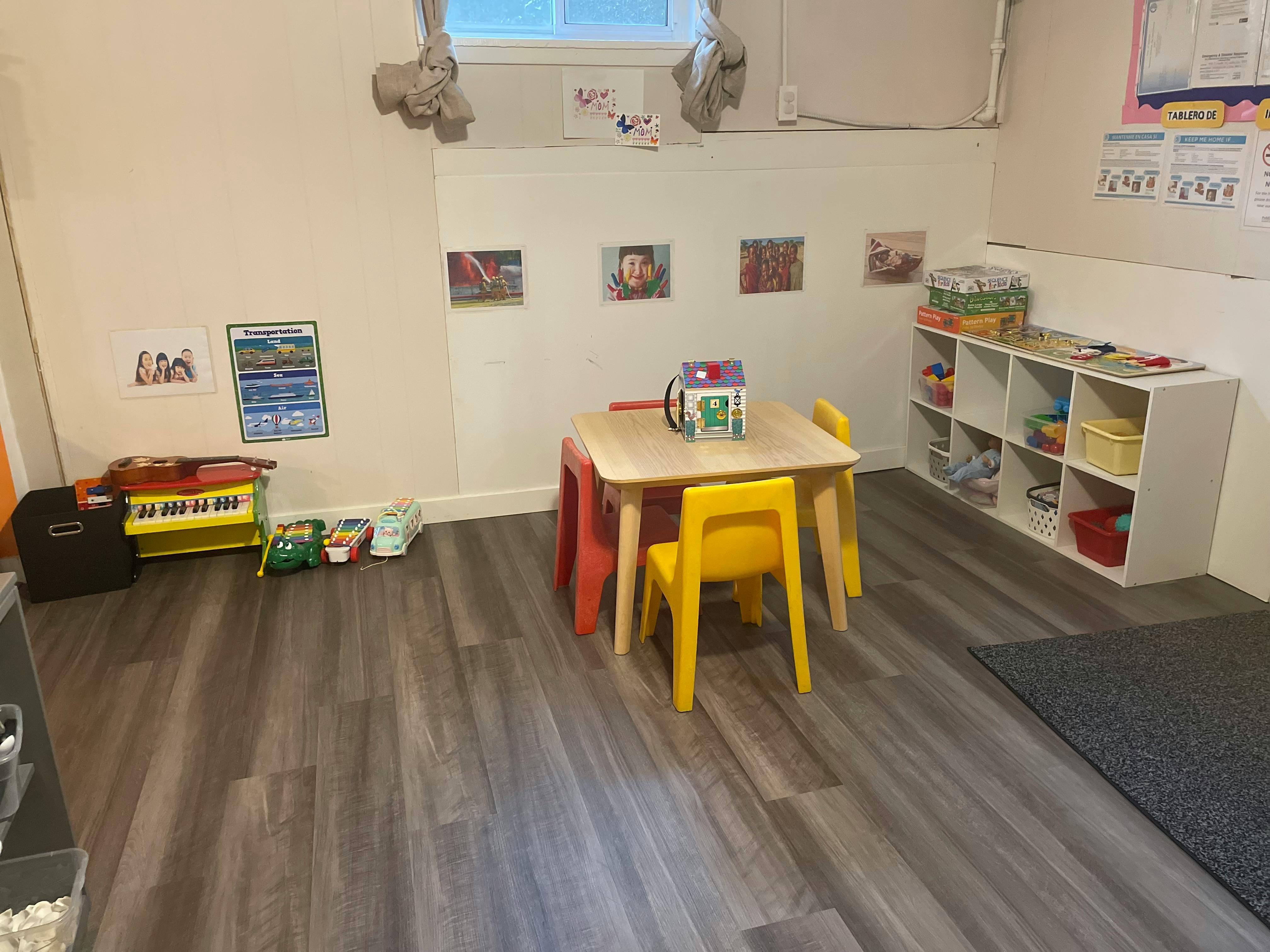 Children's play area with small table and chairs, toys, and storage shelves