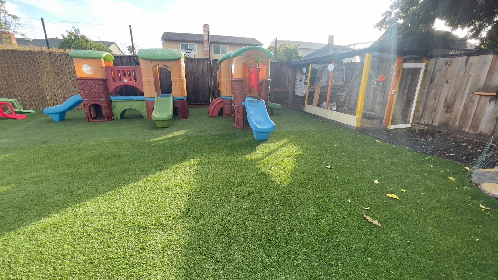 Outdoor play area with artificial turf and colorful play structures