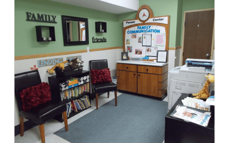 Parent communication center with chairs, bookshelf, and printer