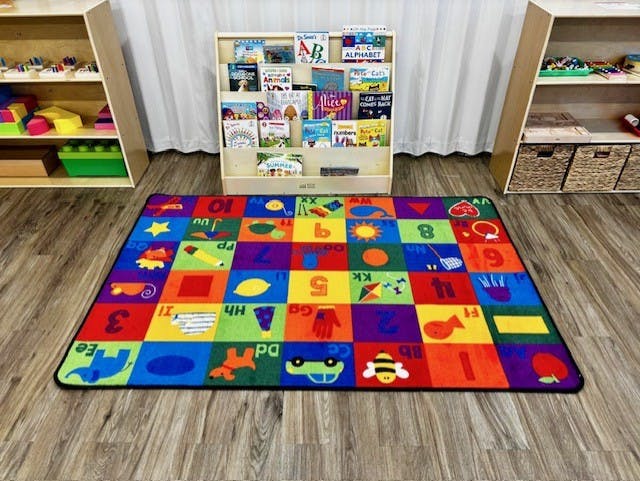 Colorful alphabet and numbers rug in a classroom
