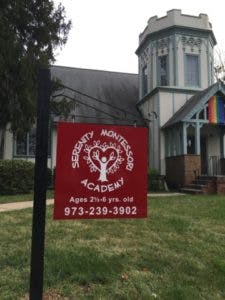 Red sign for Serenity Montessori Academy in front of a building