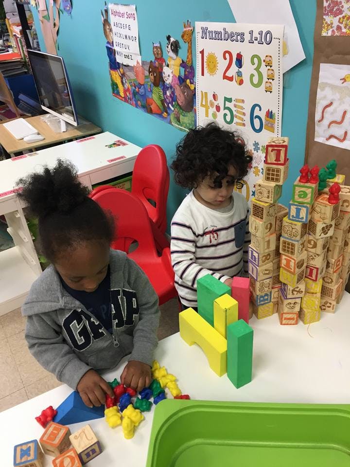 Two children playing with blocks in a classroom