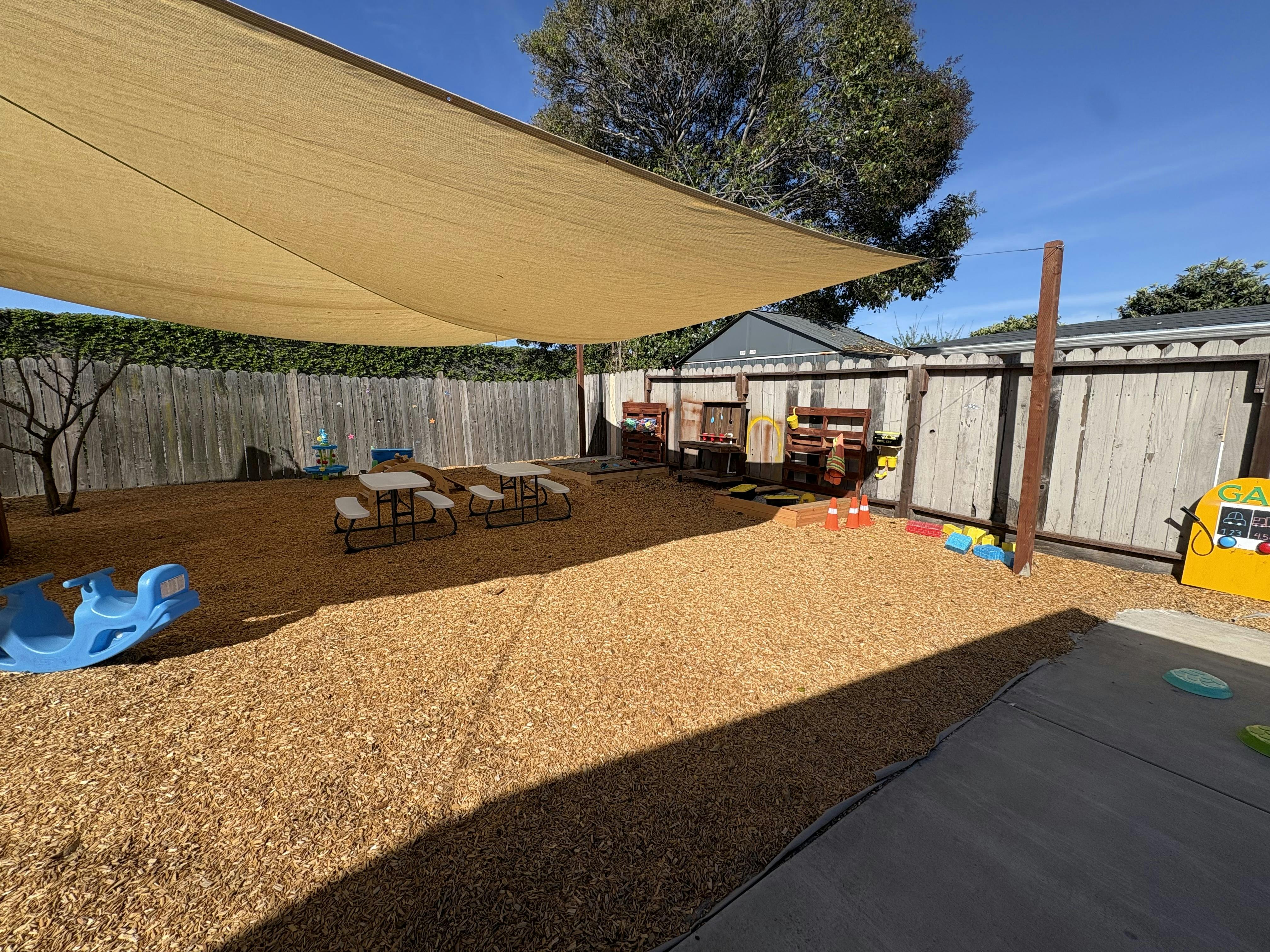 Children's playground with shade covering, picnic tables, and play equipment