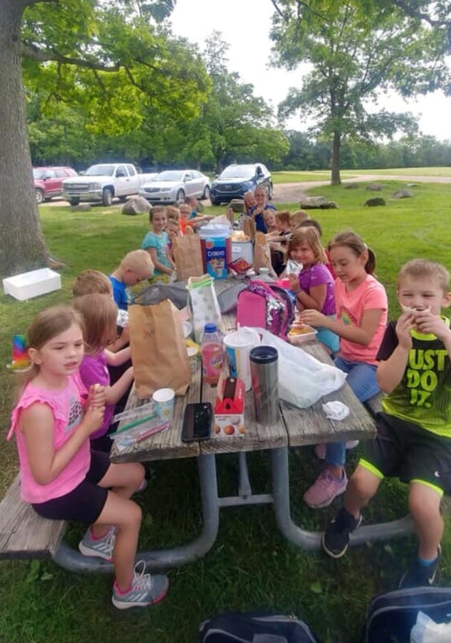 Children sitting at a picnic table outdoors