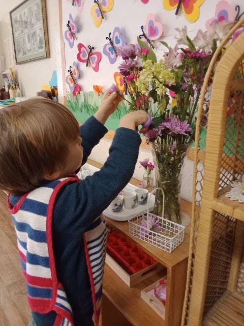 Child arranging flowers in a vase