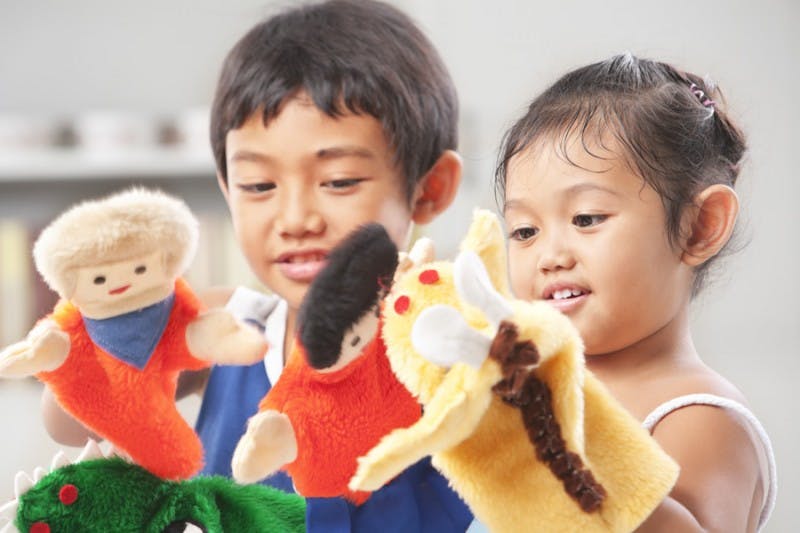 Two children playing with hand puppets